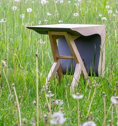 a small table sitting in the middle of some grass