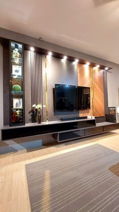 a modern living room with wood floors and large television on the wall in front of it