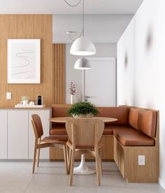 a kitchen with a table, chairs and a bench next to a wall that has wood paneling on it