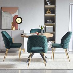 a dining room table and chairs with green velvet upholstered chairs in front of it