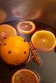 some oranges and cinnamon sticks are cooking in a pot