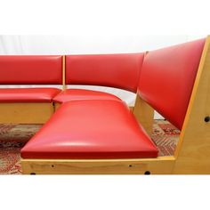 two red leather seats and a wooden bench