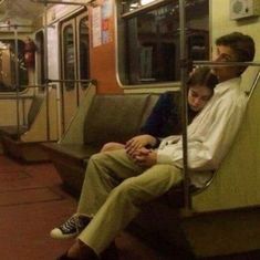 two people sitting on a subway train next to each other