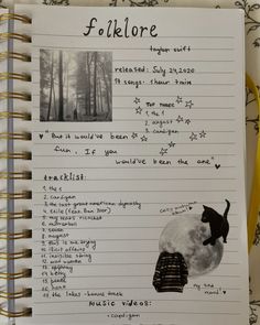 an open notebook with writing on it and pictures of cats in the woods behind it