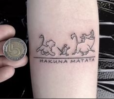 a person with a small tattoo on their arm that says hakuna matata