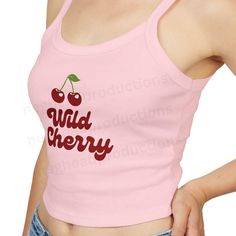 Add a pop of fun to your wardrobe with our fitted Wild Cherry Tank Top! This adorable top features a playful design with two cute cherries, making it a perfect addition to your wardrobe. This micro rib tank top features thick spaghetti straps and rests just above the belly button. It pairs effortlessly with your favorite jeans, shorts, or skirts. Available colors: ~Baby Blue ~Pink ~White Please see the detailed size chart to help you choose the right size. Fabric blend features 52% Airlume combe Trendy Pink Tops With Funny Print, Trendy Pink Top With Funny Print, Red Sleeveless Top With Cherry Print, Red Cotton Tank Top With Letter Print, Sleeveless Red Top With Cherry Print, Fitted Cherry Print Tops For Spring, Fitted Sleeveless Top With Cherry Print, Fitted Sleeveless Cherry Print Tops, Cute Sleeveless Strawberry Print Top