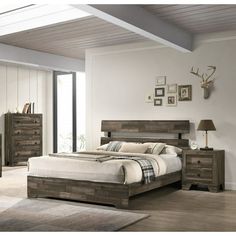 a bed room with a neatly made bed and dressers