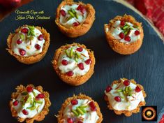 small appetizers with cream cheese and pomegranates on a black plate