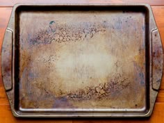 an old metal tray sitting on top of a wooden table