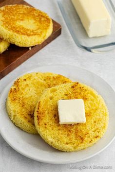 two pancakes on a white plate with butter