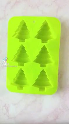 christmas tree shaped ice cube tray on a marble counter top with the words treat written below it