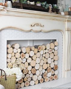 a fireplace mantel with logs stacked on top and flowers in a basket next to it