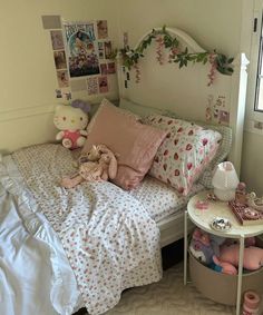 a bed with pink and white sheets, pillows and stuffed animals on top of it