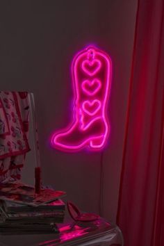 a neon boot is lit up in the corner by a red curtain and pink curtains