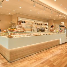 two people are behind the counter at a restaurant with food on display in front of them