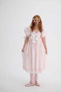 Look as delectable as a cherry blossom-infused macaron in the Confection Cottontail—a blush cotton midi-dress with puff sleeves and a pleated skirt. The contrasting bows and luscious ruffles harken back to a New Year’s celebration amid French aristocracy. Cotton midi-dress with puff sleeves and pleated skirt Contrast b Pink Puff Sleeve Dress With Voluminous Fit, Elegant Pink Victorian Spring Dress, Elegant Pink Victorian Dress For Spring, Pink Pleated Puff Sleeve Dress, Pink Pleated Dress With Puff Sleeves, Pink Dress With Ruffle Hem And Voluminous Skirt, Feminine Spring Victorian Daywear Dress, Spring Princesscore Dresses With Ruffles, Spring Victorian Dress For Party