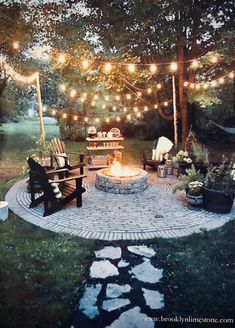 an outdoor fire pit with lights strung over it