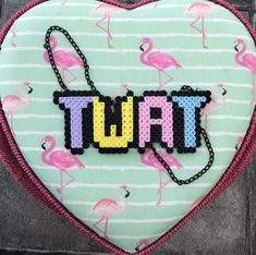 a pink flamingo heart with the word tutti spelled in letters on it's side