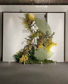 an arrangement of flowers on display in front of a wall