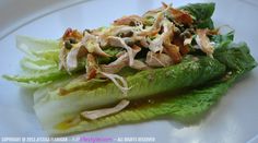 lettuce with chicken and other toppings on a white plate