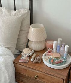 a wooden dresser topped with lots of makeup and personal care items on top of it