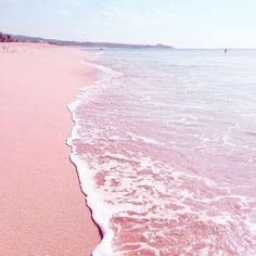 the beach is covered in pink sand and water