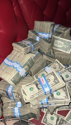 a pile of money sitting on top of a red couch