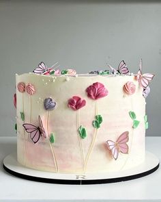 a white cake with pink and purple butterflies on it