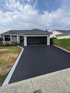 a house with an asphalt driveway in front of it