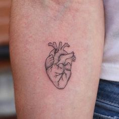 a small heart tattoo on the arm