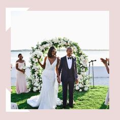 a bride and groom walking down the aisle after their wedding ceremony in front of an ocean