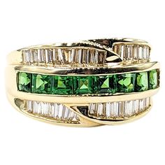 Channel Set .54ctw Tsavorite Garnets & .75ctw diamonds Ring In Yellow Gold This striking Gemstone Fashion Ring, artfully crafted in 14kt Yellow gold, boasts a vibrant .54ctw Tsavorite Garnets centerpiece, beautifully complemented by .75ctw baguette diamonds set in a sleek channel. These diamonds are of SI clarity, exhibiting a near-colorless white hue that enhances the ring's allure. The harmonious blend of the vivid green tsavorite garnets with the sparkling diamonds makes this piece truly capt Emerald Cut Green Diamond Ring With Multi-stone, Emerald Cut Green Multi-stone Diamond Ring, Green Emerald Cut Multi-stone Diamond Ring, Green Multi-stone Diamond Ring, Green Diamond Channel Set Rings, Classic Green Multi-stone Diamond Ring, Fine Jewelry Green Channel Set Ring, Green Baguette Cut Ring With Diamond Accents, Green Multi-stone Baguette Cut Rings