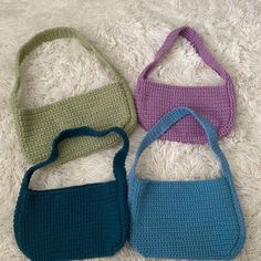 three crocheted purses sitting on top of a white carpet next to each other