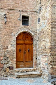 an old brick building with two wooden doors and steps leading up to the entryway