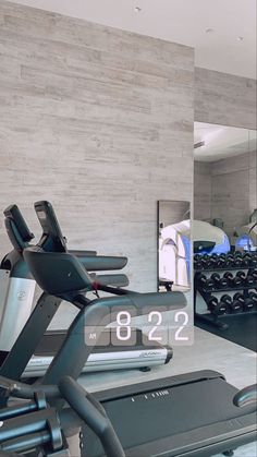 there is a gym with treads and exercise equipment in the foreground as well as a mirror