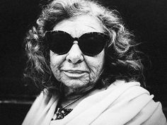 an old woman wearing sunglasses and a scarf