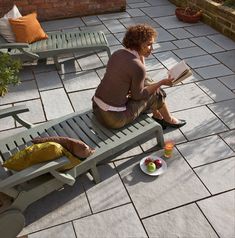 a woman sitting on a bench reading a book