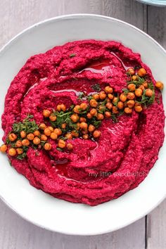 a white bowl filled with red beet hummus