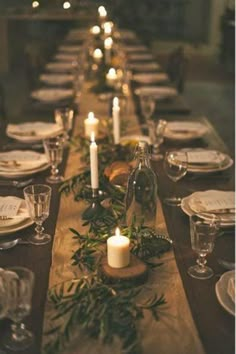 a long table is set with candles and place settings for the dinner guests to enjoy