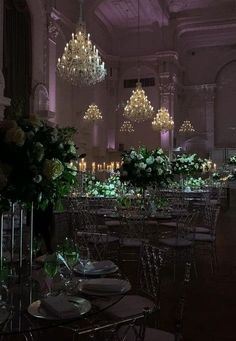 the tables are set up for an event with chandeliers hanging from the ceiling