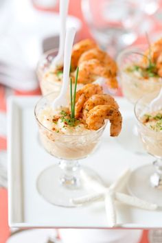 three small desserts with shrimp in them and garnishes on the side