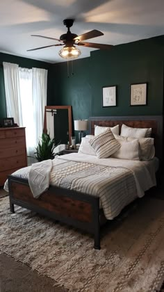 a bedroom with a bed, dresser and ceiling fan in it's center area