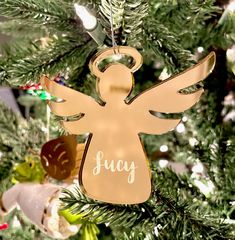 an angel ornament hanging from a christmas tree with ornaments around it and the word joy