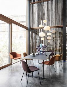 a dining table with chairs around it in front of large windows