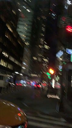 a city street filled with lots of traffic and tall buildings lit up at night time