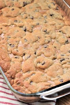 a close up of a cake in a pan on a table with a red and white towel