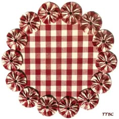 a red and white checkered table cloth with small flowers on the center, surrounded by smaller ruffles