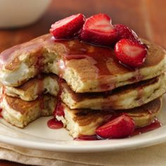 stack of pancakes with syrup and strawberries on top