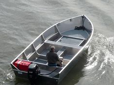 a man sitting in a small boat on the water