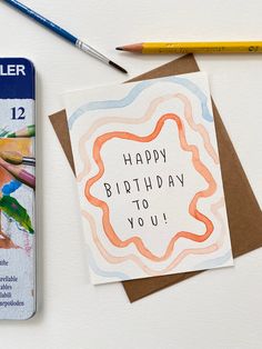 a happy birthday card with pencils next to it